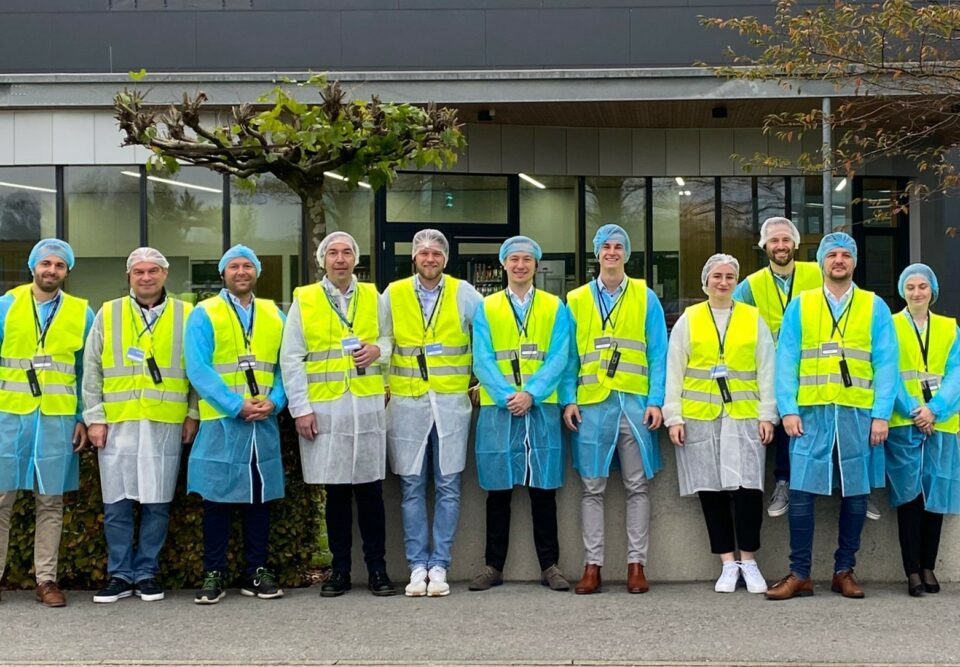 Personengruppe in Schutzkleidung vor dem ALPLA Werk.