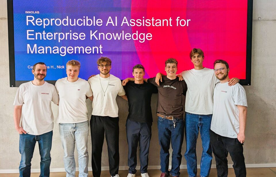 Das AI Workspace Team vor einer großen Screen, die den Lab-Titel zeigt.